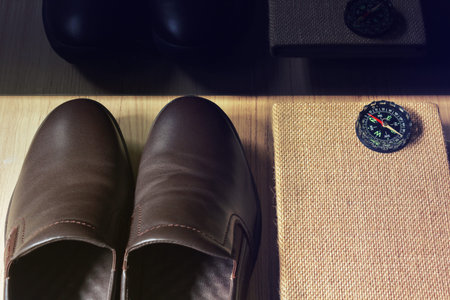 Man brown leather shoes with note book or diary with compassの写真素材