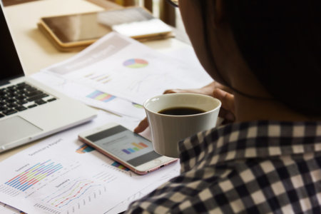 Coffee in hand with business diagram on working table,business concept