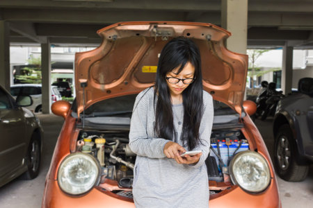 women press on mobile or smartphone, women call technician or mechanic with car broken down backgroundの写真素材