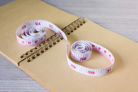 Tape measure on blank note paper or memo note  for concept of weight loss and dietの写真素材