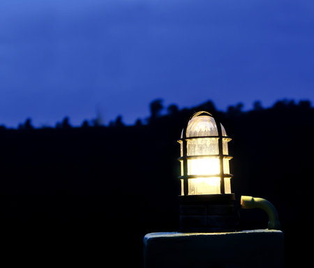 One electricity lamp or lantern, light in darkness blue skyの写真素材