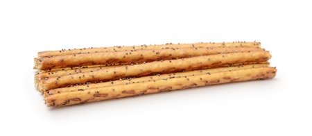 Heap of breadsticks with poppy seeds isolated on white.の写真素材