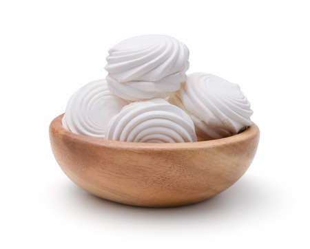 White round marshmallows in a wooden bowl isolated on white.の写真素材