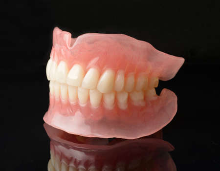 Modern full denture dentures with reflection on black.の写真素材