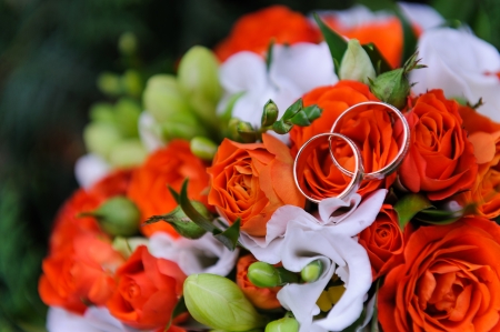 Wedding rings on a bouquet of rosesの写真素材