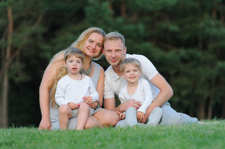 Happy parents with their children portrait smiling and having fun outdoorsの写真素材