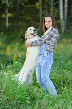 Big white dog put paws on the shoulders of its ownerの写真素材