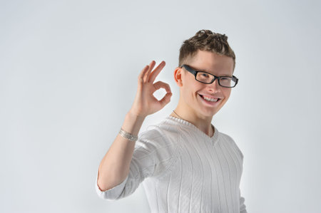 Happy young man gesturing OK sign and smilingの写真素材