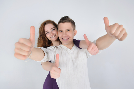 Smiling young couple showing thumbs upの写真素材