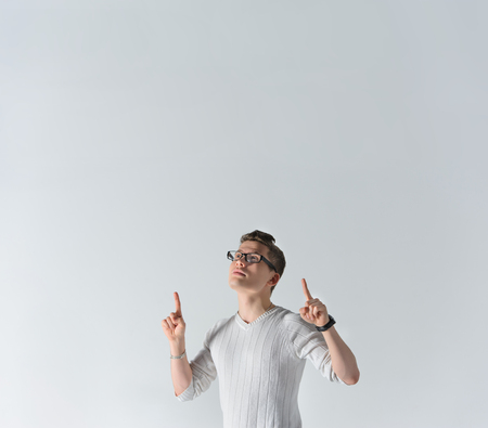 Serious young man points his forefingers upの写真素材
