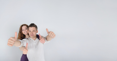 Young man with his girlfriend showing thumbs upの写真素材