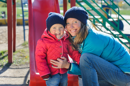A little girl and her mother playing in a playgroundの写真素材