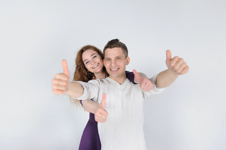 Smiling young couple showing thumbs upの写真素材