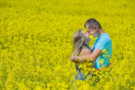 Happy couple kissing in nature at rape fieldの写真素材