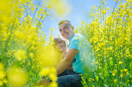 Happy couple in yellow rape field.の写真素材