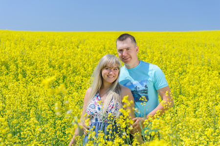 Happy couple in yellow rape field.の写真素材