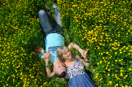Young beautiful couple lying on the grassの写真素材