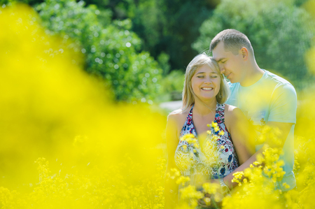 Happy couple in yellow rape field.の写真素材