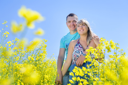 Happy couple in yellow rape field.の写真素材