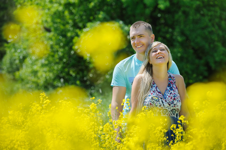Happy couple in yellow rape field.の写真素材