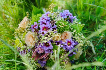 Wedding rings on wedding bouquet in flowersの写真素材