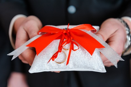 Wedding rings on decorative white pillowの写真素材