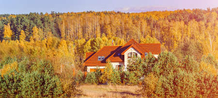 Beautiful view of peaceful house in the autumn sunlight at duskの写真素材