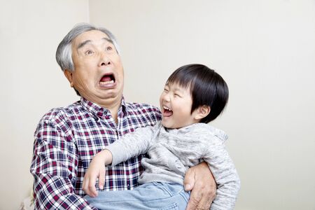 The Boy Playing with His Grandfatherの写真素材