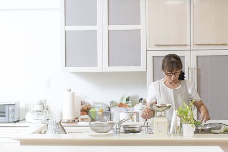 Japanese woman in the kitchenの写真素材