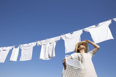 Japanese woman doing laundry on the roof on a sunny dayの写真素材