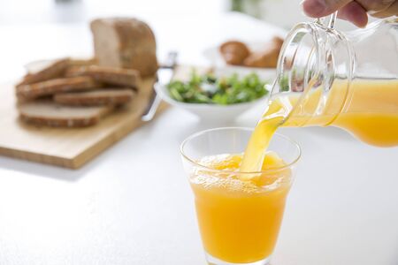 Continuous pouring of orange juice for breakfastの写真素材