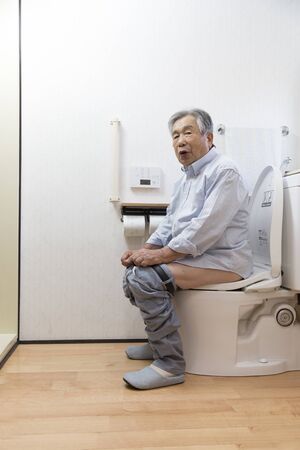 Japanese senior man defecate in the toilet at homeの写真素材