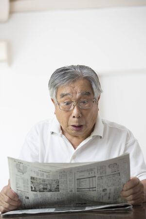 Surprised to see newspaper, old man, Japaneseの写真素材