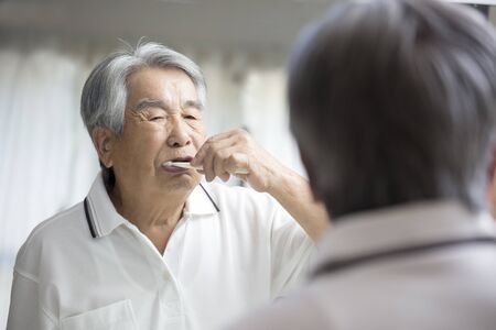 Japanese old man playing toothpasteの写真素材