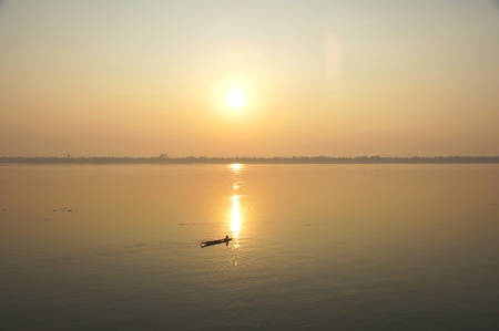 A boat crossing the Mekong River at sunset  Four thousand islands in Laosの写真素材