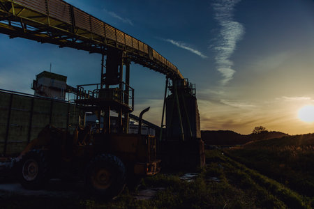 Silhouette of an oil pump in the field at sunset.の写真素材