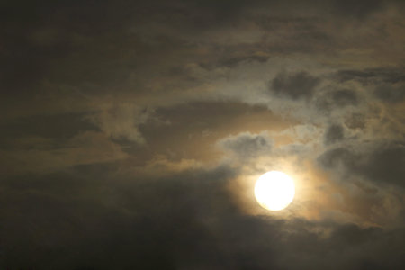 A sun similar to the full moon seen from the cloudy sky