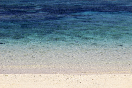 The white sandy beaches of the resort and the waves of the blue seaの写真素材