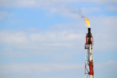 A view of the flame rising from the chimney of an oil complexの写真素材