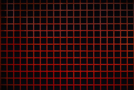 Background material photo close-up on a wall decorated with a red painted wooden lattice