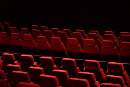 Red seats lined up in the theaterの写真素材