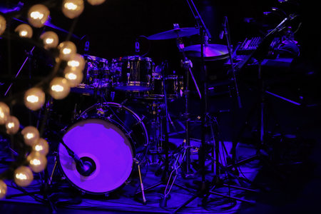 A drum set on the stage of a dimly lit live music venue before the show beginsの写真素材