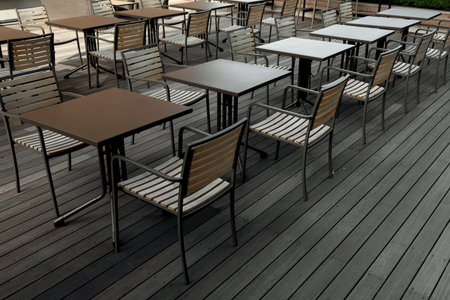 Cafe tables lined up in the wooden deck courtyard