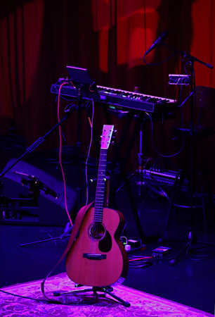 A guitar and an electronic piano on the stage of a dimly lit live music venue before the show beginsの写真素材