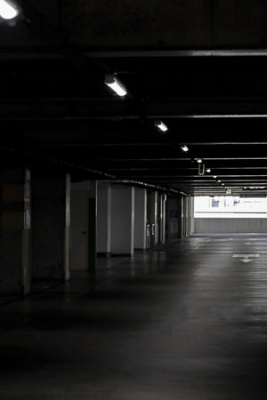 A dimly lit multi-story parking garage in a commercial building, even during the dayの写真素材
