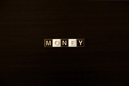 MONEY word tiles on dark background: Concept of finance, investment, and wealth