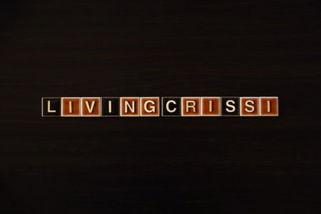 LIVING CRISIS word tiles on dark background: Concept of cost of living crisis and economic hardship