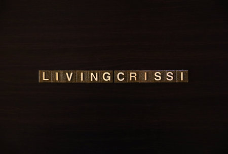 LIVING CRISIS word tiles on dark background: Concept of cost of living crisis and economic hardship