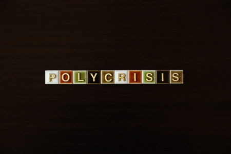 "POLYCRISIS" word tiles on dark background: Concept of interconnected global crisesの写真素材
