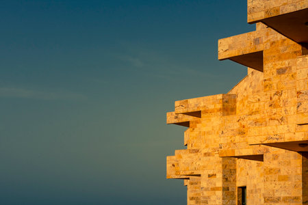 Generic architecture of a residential apartment building, side view, with integrated balconies and blue sky during golden hour. Creative Edit.のeditorial素材